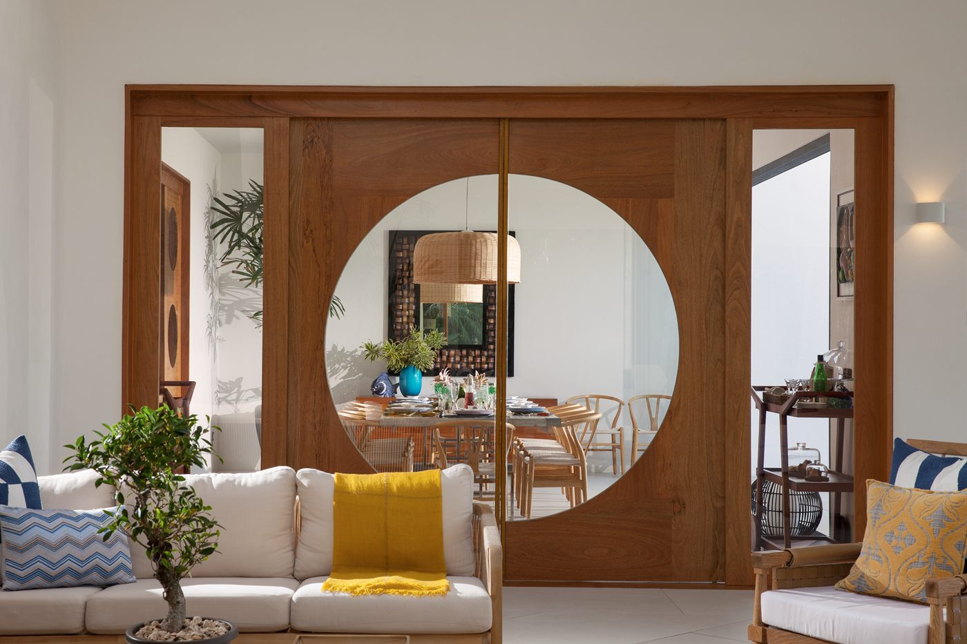 Tabique con una gran abertura circular que deja ver el comedor desde la sala